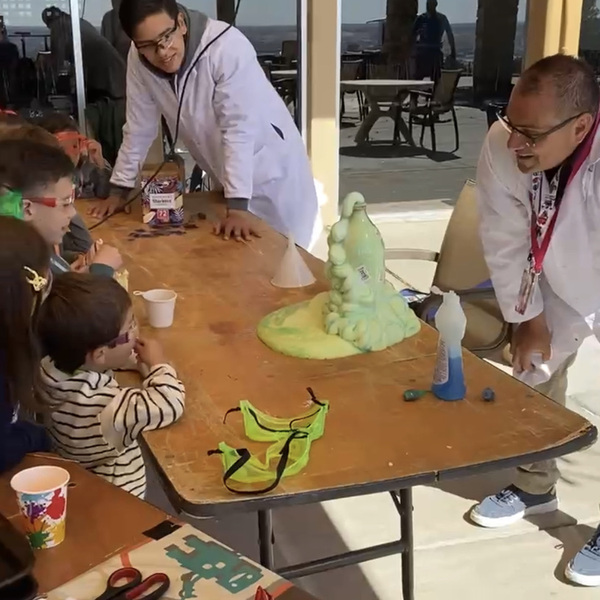 Insights team members performing an interactive science experiment with children